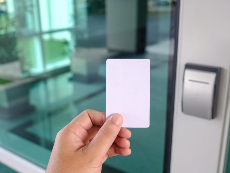 Hand using security key card scanning to open the door to entering office building or home or bank
